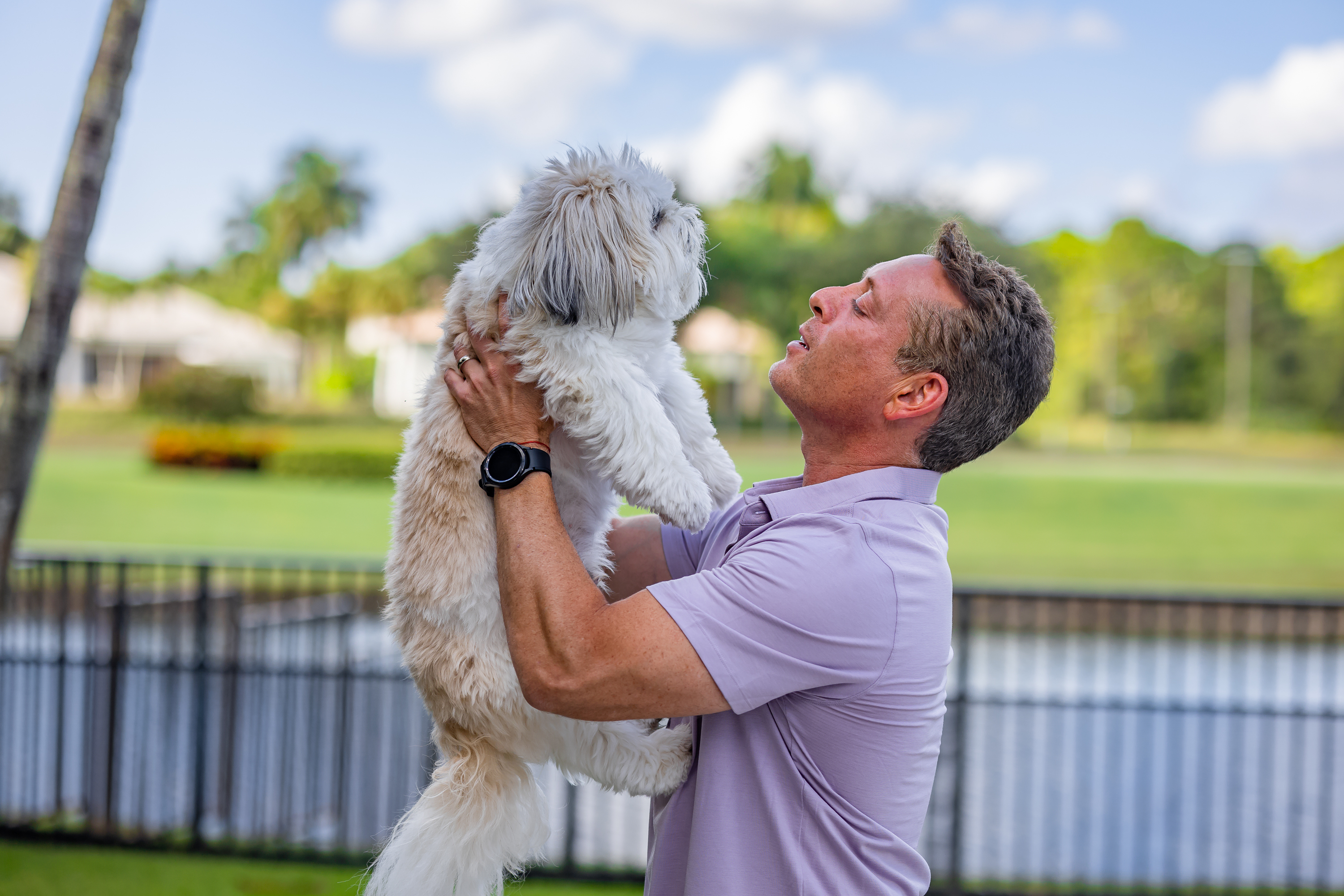 Happy customer playing with his protected fluffy white dog