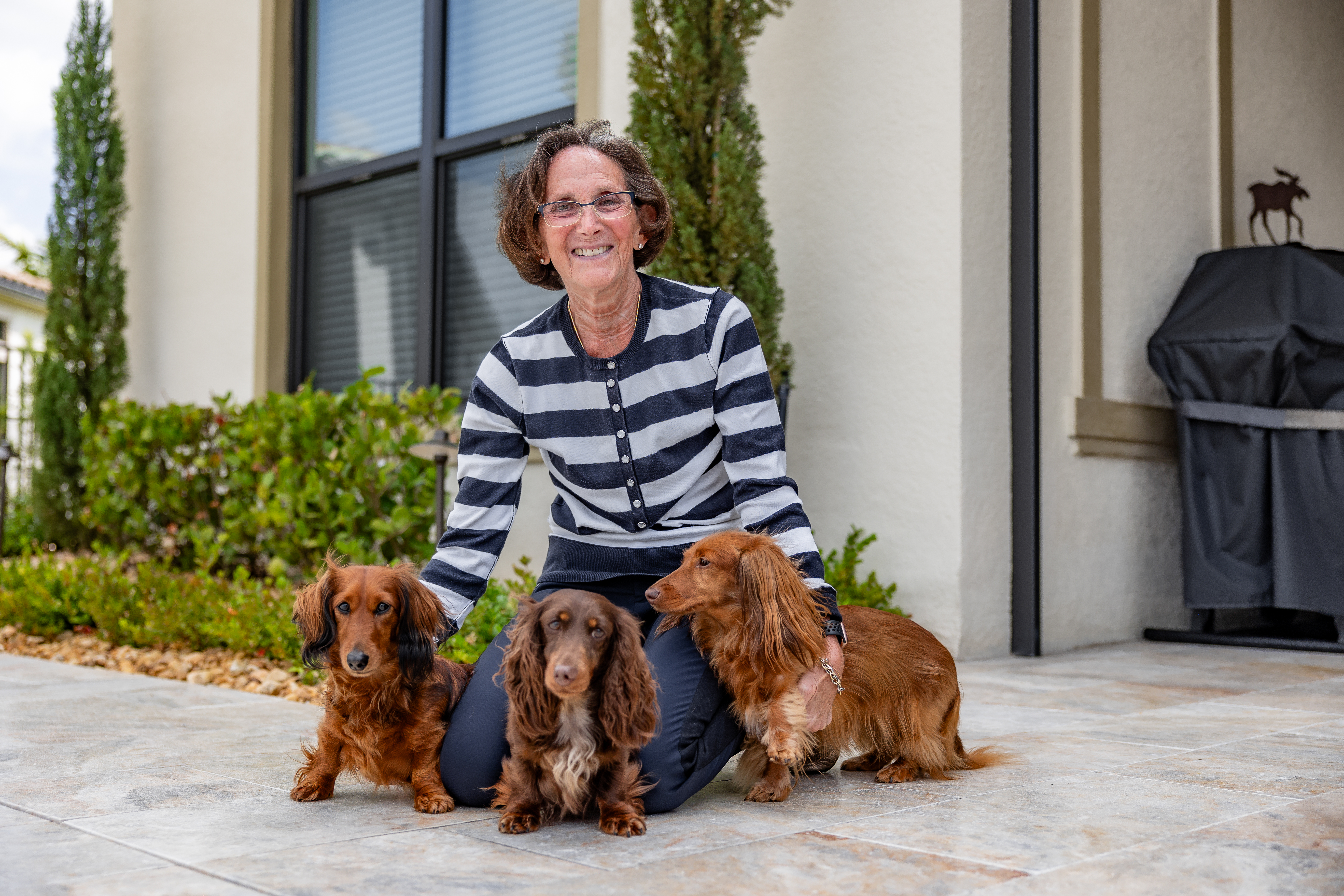 Woman with her three beloved dachshund dogs